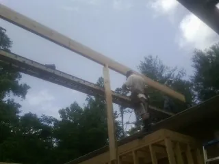Carpenter setting a ridge beam over a new addition frame — Ice Dam Removal by Roofing Brothers in West Simsbury