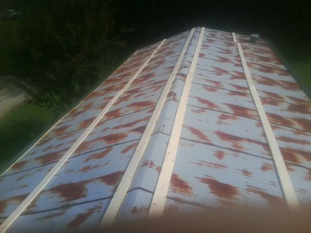 Rusted metal roof panels with new wood purlins before replacement — Storm Damage Roof Repair in West Simsbury by Roofing Brothers
