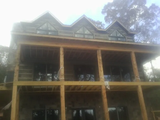 Dormers and porch framing on a large log home under construction — Roof Coating work by our crew in West Simsbury