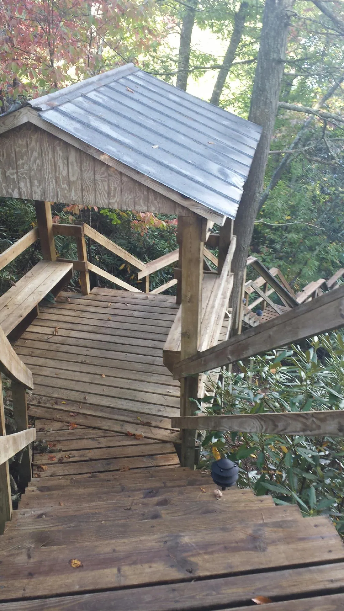 Metal roofed shelter over wooden steps on a wooded walkway — Skylight Repair & Installation work by our crew in West Simsbury